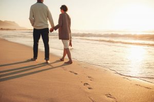 Couple walking on the beach while holding hands
