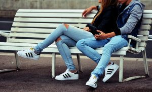 Couple sitting on bench with matching shoes
