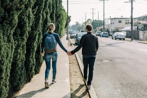 Couple holding hands walking down the road