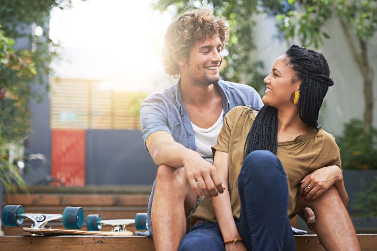 Couple sitting on deck with skateboard