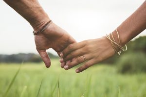 Hands holding in field